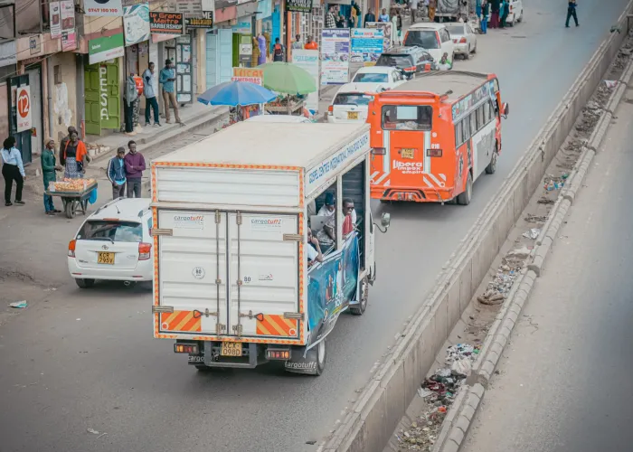 Aerial view of a bustling street in Nairobi featuring vehicles, pedestrians, and roadside shops.