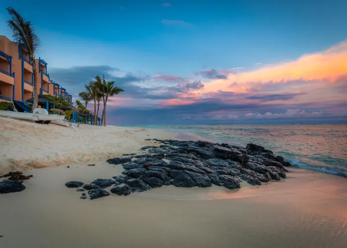 Breathtaking sunset view at a serene beach in Quatre Cocos, Mauritius, with golden sands and azure waves.