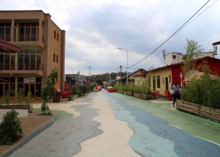 Dynamic street scene in Nyamirambo, Kigali with colorful architecture and vibrant patterns.