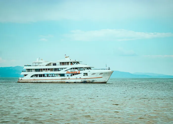 Large white yacht floating on Lake Kivu, surrounded by scenic views from Bukavu, Congo.