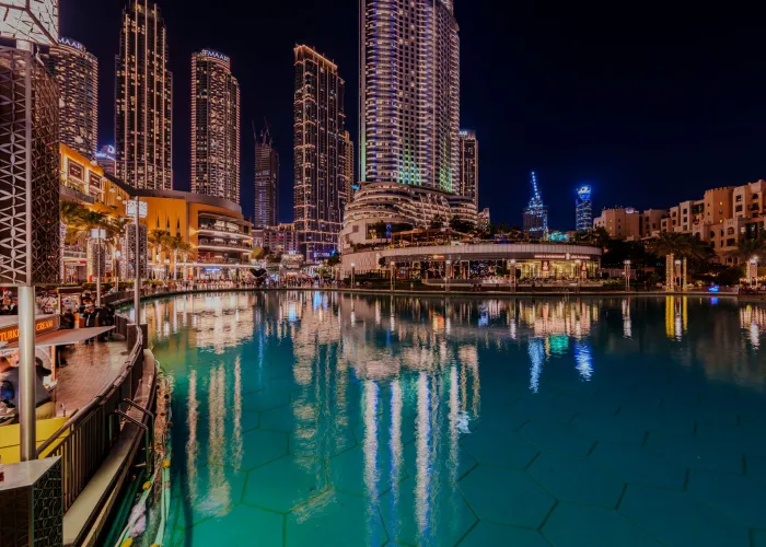 Captivating night view of Dubai's cosmopolitan skyline reflecting in a serene pond.